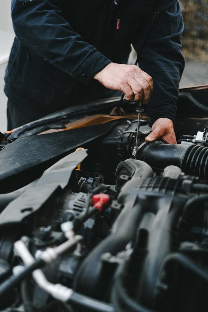 An Auto Mechanic Repairing the Car Engine